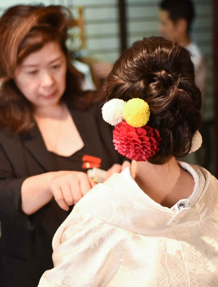 白無垢の着付けを仕上げる美容師