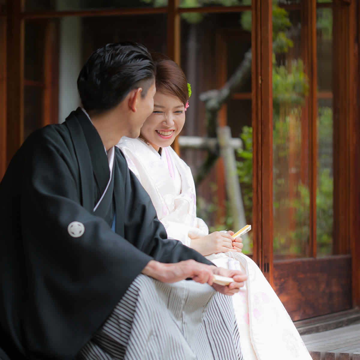 縁側で談笑をする和服姿の新郎新婦